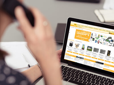 frau im bro schaut auf laptop und telefoniert