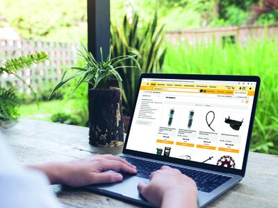 Mockup image of a woman using and typing on laptop with blank white desktop screen with nature background