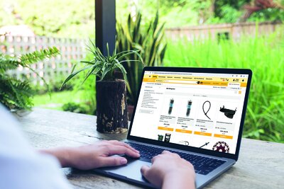 Mockup image of a woman using and typing on laptop with blank white desktop screen with nature background