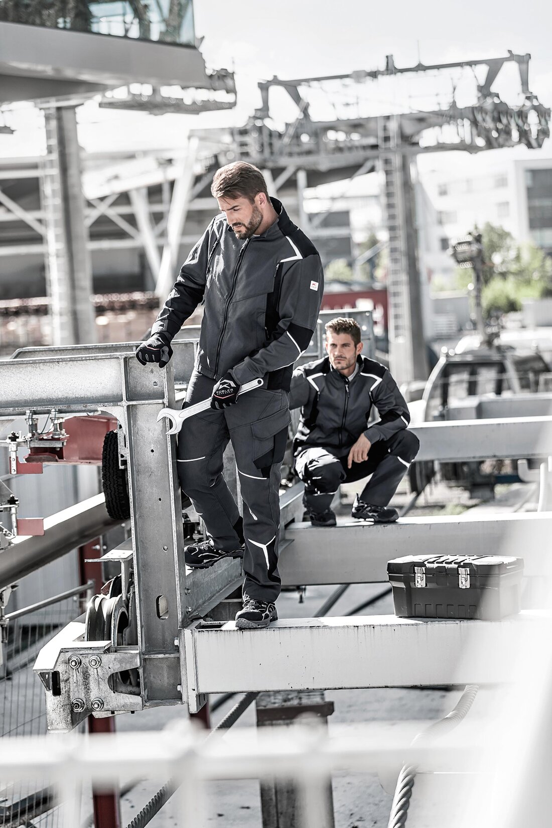 Zwei Arbeiter mit Arbeitskleidung.